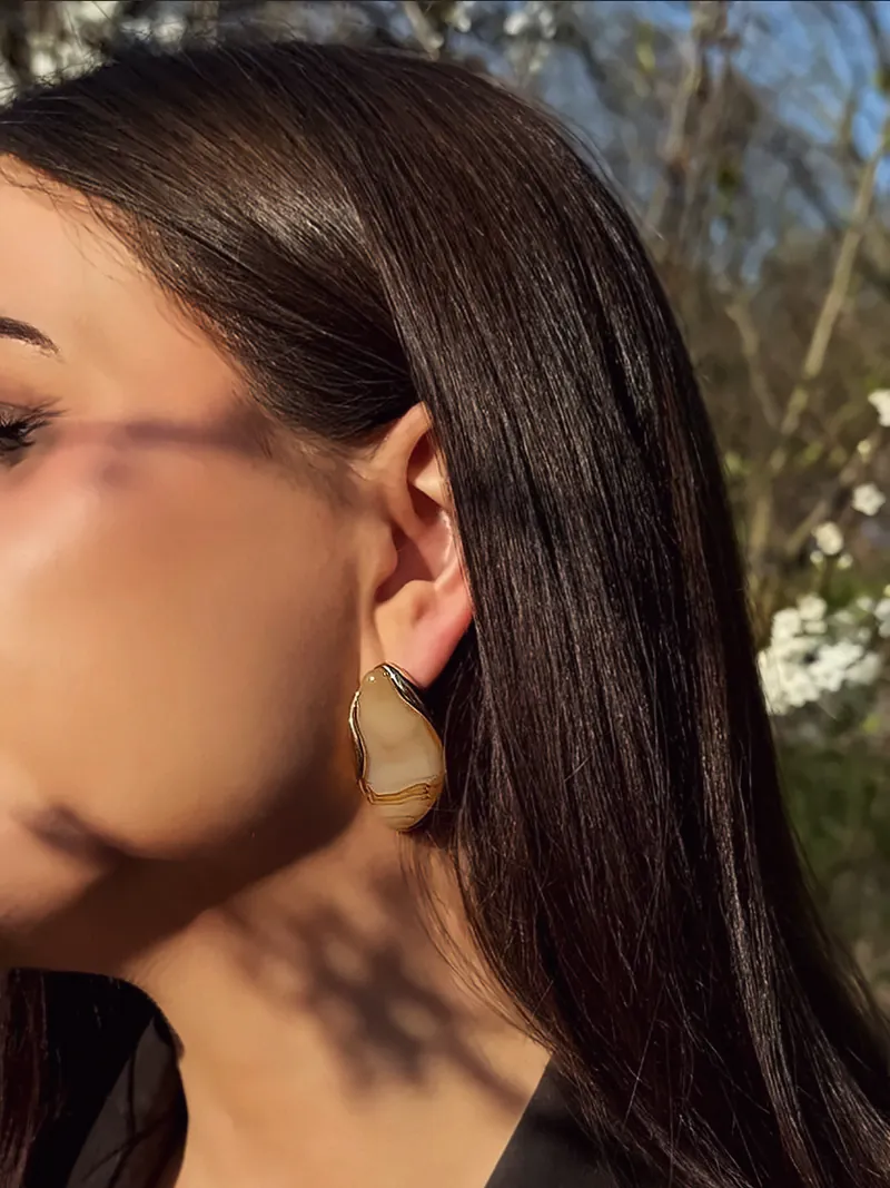 Karolina, das Model von Aurivienne, im Sonnenlicht mit den Desert Muse Ohrringen aus Edelstahl.
