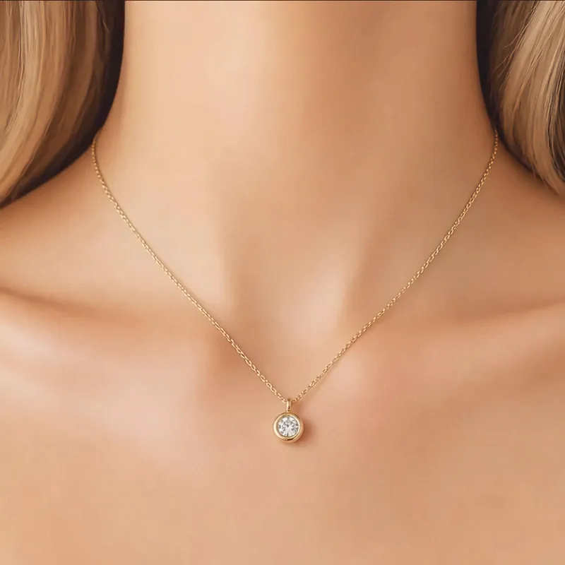 Feine goldene Kette mit einem gefassten Stein am Hals.